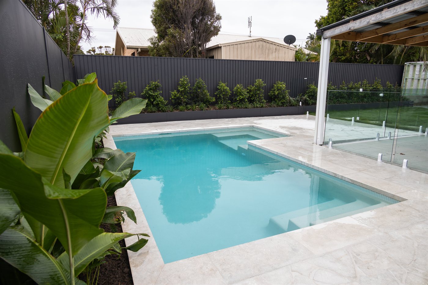 Concrete pool and travertine surrounds built by The QLD Group on the Sunshine Coast